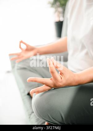 Close-up des mains d'une femme asiatique en pose mudra de méditation à la maison, concept de yoga, pleine conscience, respiration, relaxation, soulagement du stress, bien-être et introspection Banque D'Images