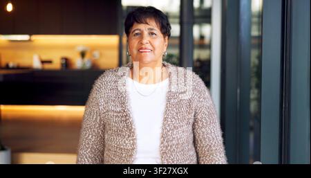 Portrait, sourire et femme âgée à la maison avec confiance, bonheur ou attitude positive en retraite. Heureuse, propriétaire féminine et pause du week-end Banque D'Images