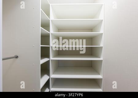 photo nette et minimaliste d'un système de placard encastré blanc et vide avec plusieurs étagères, offrant un espace de rangement généreux Banque D'Images