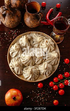 Dumplings khinkali géorgiens avec du vin sur une table rustique Banque D'Images