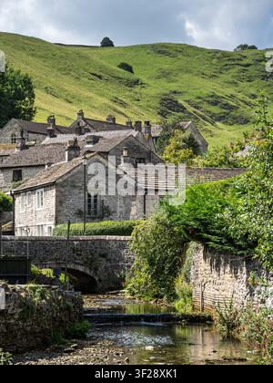 Cabanes en pierre historiques et un petit pont de pierre sur le Peakshole Water à The Stones dans le village pittoresque de Castleton, Derbyshire, Royaume-Uni Banque D'Images