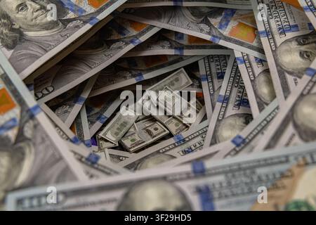 Petits piles de billets à l'intérieur d'un tunnel tourbillonnant de billets de cent dollars américains Banque D'Images
