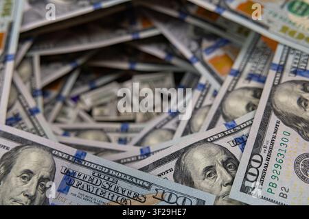 Petits piles de billets à l'intérieur d'un tunnel tourbillonnant de billets de cent dollars américains Banque D'Images