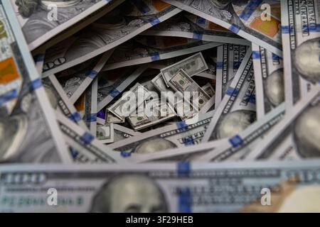 Petits piles de billets à l'intérieur d'un tunnel tourbillonnant de billets de cent dollars américains Banque D'Images