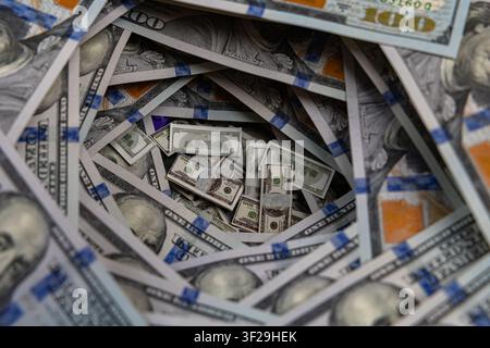 Petits piles de billets à l'intérieur d'un tunnel tourbillonnant de billets de cent dollars américains Banque D'Images