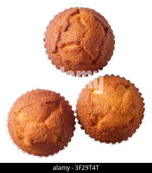 trois muffins simples cuits isolés sur fond blanc, génoise dorée dans des moules en papier, gros plan vue de dessus Banque D'Images