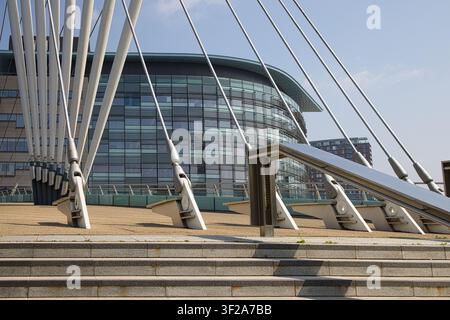 Un plan en perspective des points d'ancrage des câbles d'acier lourds et des supports structurels de la passerelle MediaCityUK devant des bâtiments modernes. Banque D'Images