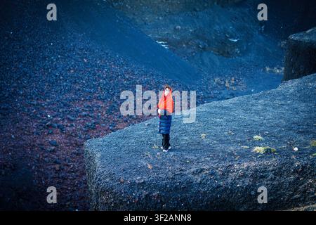Une personne se tient seule sur un affleurement rocheux dans un paysage aride. Banque D'Images