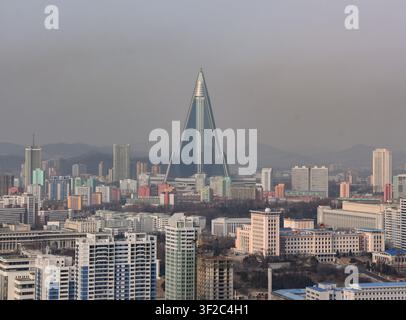 Vue aérienne de l'hôtel Ryugyong de forme pyramidale s'élevant au-dessus de la skyline urbaine dense de bâtiments résidentiels et d'infrastructures urbaines à Pyongyang, P Banque D'Images