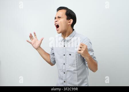 Expression d'un homme indonésien asiatique fou et en colère sur fond isolé Banque D'Images