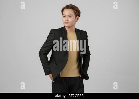 Portrait d'un homme d'affaires asiatique heureux portant un costume sur un fond isolé Banque D'Images
