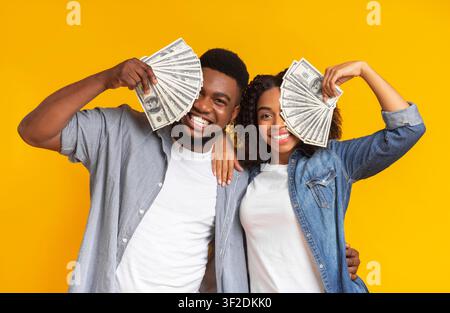 Un homme et une femme chanceux qui détiennent beaucoup de dollars en espèces Banque D'Images
