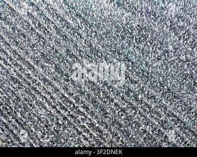 Un gros plan détaillé montre une surface très texturée composée de nombreux petits fragments gris irréguliers et scintillants avec des touches de couleurs subtiles Banque D'Images