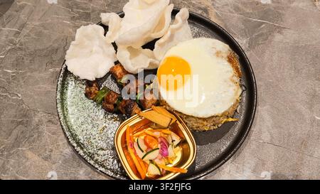 Riz frit indonésien traditionnel préparé avec des assaisonnements savoureux et servi comme un plat réconfortant local populaire. Banque D'Images