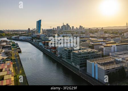 Vue aérienne de la zone portuaire d'Osthafen avec des bâtiments de bureaux modernes le long de la rivière Main, la BCE et la ligne d'horizon de Francfort en arrière-plan au coucher du soleil en Banque D'Images