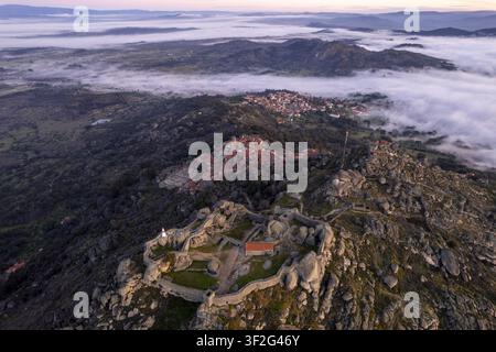 Vue aérienne du village historique de Monsanto et de ses ruines de château ancien perchées sur une colline rocheuse, entourées de brume matinale à Monsanto, Caste Banque D'Images