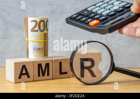 Concept AMLR 2027. Règlement Anti-Blanchiment d'Argent, symbole AMLR sur des cubes en bois, rouleau de billets en euros, loupe et calculatrice. Nouvelle EU fina Banque D'Images