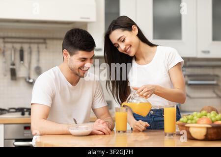 Jeune homme et femme caucasiques profitant d'un jus d'orange Banque D'Images