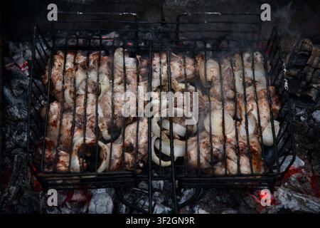 Barbecue portatif chaud et vide avec feu flamboyant et charbon de bois sur fond noir. En attente de l'emplacement de vos aliments. Gros plan Banque D'Images
