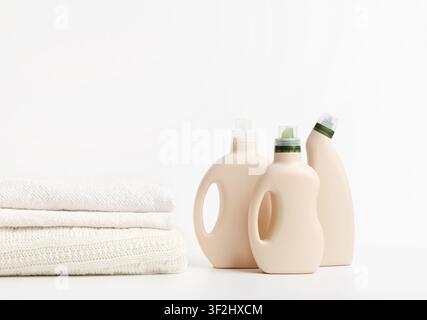 Pile de serviettes blanches supplémentaires et de bouteilles de recyclage sur blanc Banque D'Images
