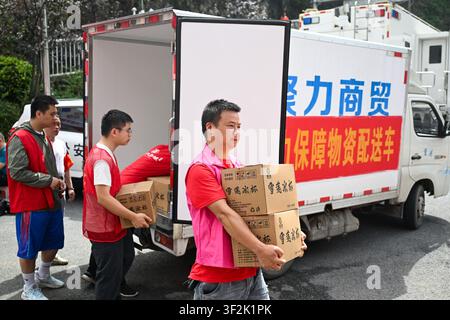 (260719) -- CHONGQING, 19 juillet 2026 (Xinhua) -- Des volontaires transfèrent des provisions près du site de sauvetage d'un éboulement dans le comté autonome miao et tujia de Pengshui à Chongqing, dans le sud-ouest de la Chine, le 19 juillet 2026. Un éboulement induit par les pluies s'est produit à 9 h 08 le vendredi dans le sous-district de Hanjia à Pengshui, ensevelissant plus de 10 bâtiments résidentiels, laissant certains résidents locaux piégés et portés disparus. La Chine a activé une réponse d'urgence nationale de niveau II pour les catastrophes géologiques. Plusieurs forces de sauvetage, y compris la réponse d'urgence, le contrôle des incendies et la sécurité publique r Banque D'Images