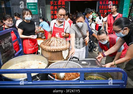 (260719) -- CHONGQING, 19 juillet 2026 (Xinhua) -- Des volontaires se préparent à livrer des déjeuners aux sauveteurs dans une cantine près du site de sauvetage d'un éboulement dans le comté autonome Miao et Tujia de Pengshui à Chongqing, dans le sud-ouest de la Chine, le 19 juillet 2026. Un éboulement induit par des précipitations s'est produit à 9 h 08 le vendredi dans le sous-district de Hanjia à Pengshui, ensevelissant plus de 10 bâtiments résidentiels, laissant certains résidents locaux piégés et portés disparus. La Chine a activé une réponse d'urgence nationale de niveau II pour les catastrophes géologiques. Plusieurs forces de sauvetage, y compris la réponse d'urgence, Banque D'Images