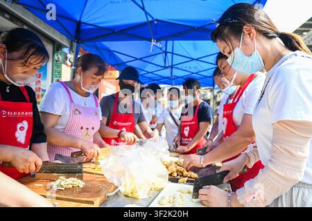 (260719) -- CHONGQING, 19 juillet 2026 (Xinhua) -- Des volontaires préparent des plats dans une cantine temporaire près du site de sauvetage d’un éboulement de montagne dans le comté autonome Miao et Tujia de Pengshui à Chongqing, dans le sud-ouest de la Chine, le 19 juillet 2026. Un éboulement de montagne induit par des précipitations s’est produit à 9 h 08 le vendredi dans le sous-district de Hanjia à Pengshui, ensevelissant plus de 10 bâtiments résidentiels, laissant certains résidents locaux piégés et portés disparus. La Chine a activé une réponse d’urgence nationale de niveau II pour les catastrophes géologiques. Plusieurs forces de sauvetage, y compris la réponse d’urgence, le contrôle des incendies a Banque D'Images