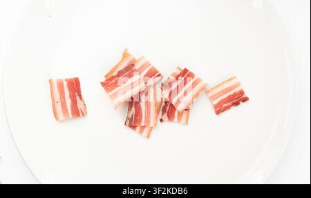 Porc carbonara séché isolé, tranches de bacon fumé cru, tranches de brisket rayées, bacon fin et frais tranché sur fond blanc, vue par-dessus Banque D'Images
