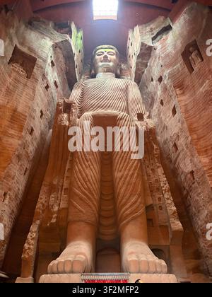11 novembre 2025, Leshan, Sichuan, Chine – Vue intérieure rare de la sculpture en pierre du Grand Bouddha de Leshan, site du patrimoine mondial de l'UNESCO, montrant les robes entièrement sculptées et le visage vu d'en bas. Banque D'Images