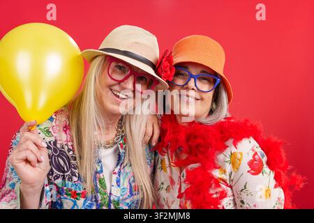 Femmes mûres heureuses profitant d'une fête, embrassant une longévité active Banque D'Images