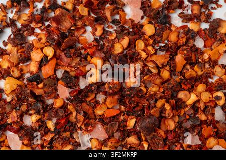 Motif de poudre de piment séché, épice rouge au piment avec sel vu de dessus. Texture de paprika épicé haché, fond d'assaisonnement au piment moulu rouge, cayenne chaud Banque D'Images