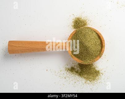 Poudre d'herbe verte dans un bol, pousses d'orge broyées sèches isolées. Texture de supplément de pousses de blé, superaliments de blé biologique, citronnelle ou moringa sur blanc Banque D'Images