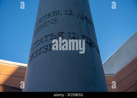 Nuremberg, Allemagne – 26 décembre 2024 : Une vue en contre-plongé capture le texte détaillé gravé sur une colonne en pierre sous un ciel bleu éclatant. La messa gravée Banque D'Images