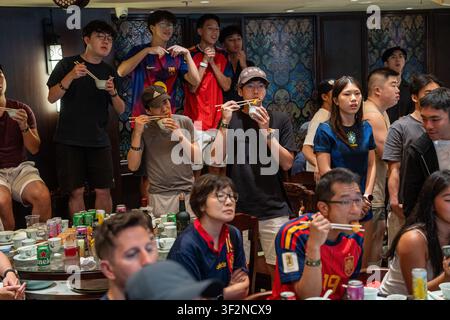Des fans regardent la finale de la Coupe du Monde en mangeant du dim sum au Lin Heung Lau, le restaurant de dim sum qui propose une diffusion en direct de la Coupe du Monde tout en servant du dim sum traditionnel aux fans à Hong Kong, le 20 juillet 2026. NEXPHER/Vernon Yuen Banque D'Images