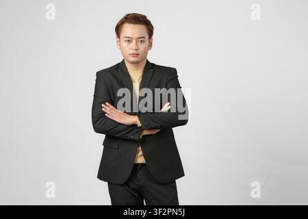 Portrait d'un homme d'affaires asiatique heureux portant un costume avec les bras croisés sur un fond isolé Banque D'Images