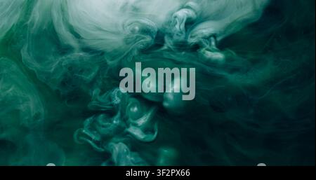 Explosion de fumée. Flux de vapeur. Tourbillon d'émulsion de brume turquoise, encre mélangée sous l'eau. Dissoudre le pigment de couleur, fond noir abstrait. Banque D'Images