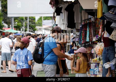 BANGKOK, THAÏLANDE - 12 JUILLET 2026 : Famille de touristes explorant un marché extérieur à Bangkok, vue de profil Banque D'Images