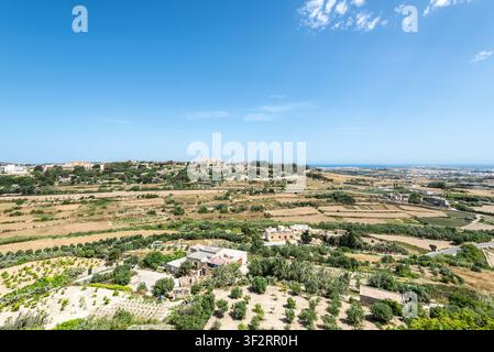 Vues panoramiques du centre de Malte depuis les remparts fortifiés de Mdina, montrant des terres agricoles ondulées, des maisons dispersées, des vallées verdoyantes et une côte lointaine Banque D'Images