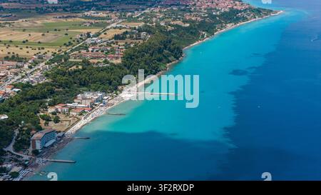 Kallithea, Grèce, 9 juillet 2026. Une vue aérienne d'une ville côtière avec une promenade de sable fin, des jetées et une eau turquoise le long du rivage. Banque D'Images