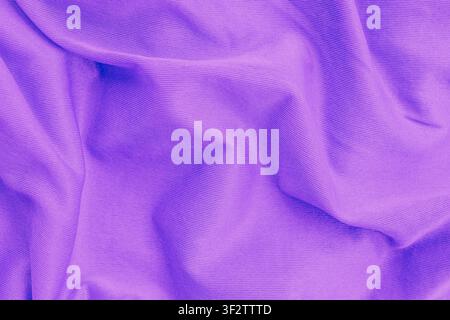 Vue horizontale en gros plan par-dessus d'une texture de tissu en coton violet froissé avec des ondulations douces et des plis élégants créant un fond textile lisse Banque D'Images