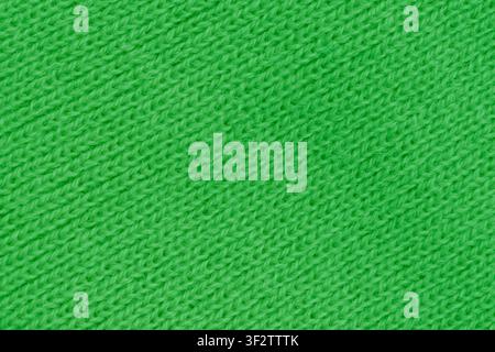 Vue macro en gros plan horizontale d'une texture de tissu en laine tricoté vert vif avec un motif de points diagonaux sans couture pour un design de fond d'hiver chaud Banque D'Images