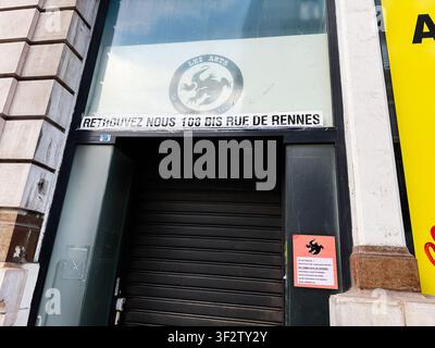 Paris, France – 14 mai 2026 : Volet roulant noir fermé et entrée avec signalétique et une affiche sur une rue de Paris en France. Banque D'Images