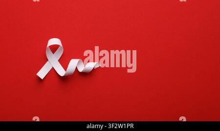 Ruban blanc symbolique de sensibilisation sur fond rouge vif Banque D'Images