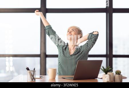 Bonne Femme D'Affaires À L'Ordinateur Portable Qui S'Étire Après Une Pause Au Bureau Banque D'Images