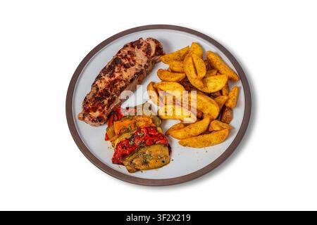 Steak de bœuf grillé avec des wedges de pommes de terre assaisonnées et des poivrons rôtis dans l'assiette Banque D'Images