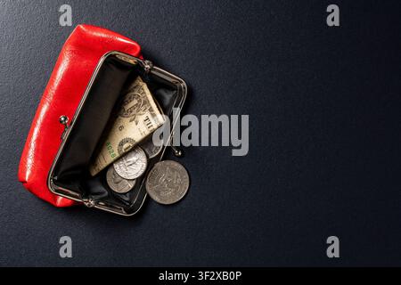 Portemonnaie en cuir rouge ouvert avec billet de dollar américain et pièces de monnaie. Vue de dessus d'une petite bourse à monnaie en cuir rouge ouverte contenant un billet d'un dollar et des pièces américaines en argent Banque D'Images