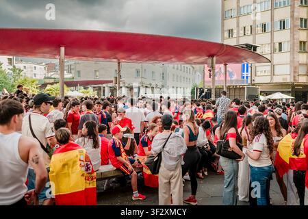 Des fans de football enthousiastes se rassemblent sur une place publique, partageant leur excitation et célébrant en regardant un match diffusé en direct sur un grand écran extérieur Banque D'Images