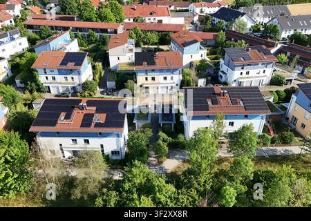 La photographie aérienne montre plusieurs maisons individuelles et maisons mitoyennes dans un quartier résidentiel moderne avec des systèmes photovoltaïques à grande échelle sur les toits. Les modules solaires utilisent une grande partie des surfaces des toits pour la production d'électricité durable Banque D'Images