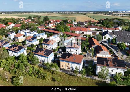 La photographie aérienne montre plusieurs maisons individuelles et maisons jumelées dans un quartier résidentiel moderne avec des systèmes photovoltaïques à grande échelle sur les toits. Les modules solaires utilisent une grande partie des surfaces des toits pour une production d'énergie durable. Banque D'Images