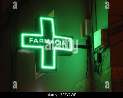 Panneau néon vert d'une pharmacie sur un vieux mur de rue à Naples (Italie) Banque D'Images